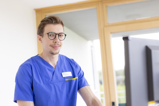 Pflegekraft arbeitet am Computer in heller Klinikumgebung