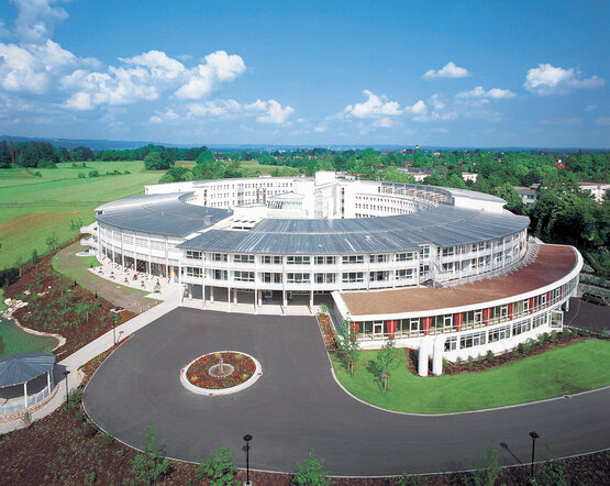 Luftaufnahme Schön Klinik Bad Aibling Harthausen, halbkreisförmige Klinik mit großen Fensterfronten im Grünen