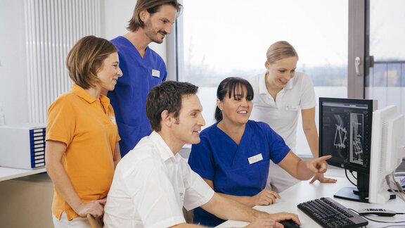 Interdisziplinäres Klinikteam bespricht gemeinsam Röntgenbilder am Computer