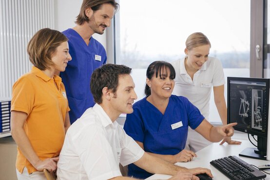 Interdisziplinäres Klinikteam bespricht gemeinsam Röntgenbilder am Computer