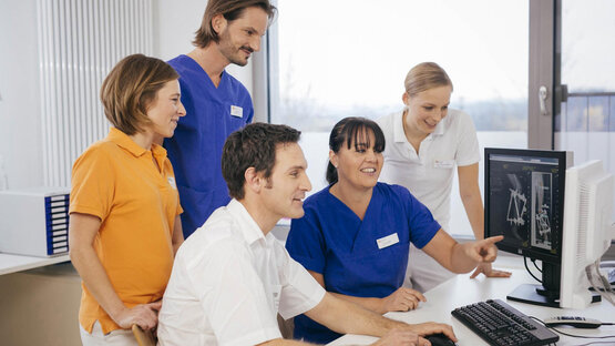 Interdisziplinäres Klinikteam bespricht gemeinsam Röntgenbilder am Computer