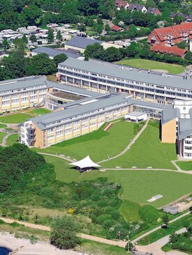 Luftaufnahme der Schön Klinik Neustadt mit grüner Umgebung und Küstenlinie