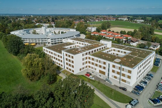 Luftaufnahme der Schön Klinik Bad Aibling Harthausen mit begrünten Flachdächern, umgeben von Bäumen und Grünflächen