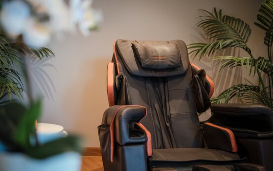 Massagesessel im Klinik mit grünen Pflanzen und sanfter Beleuchtung auf Holzfußboden