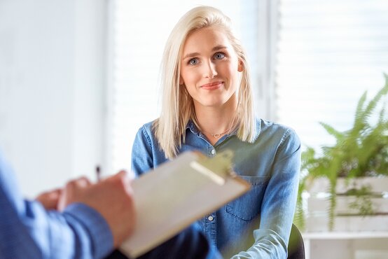Blonde Frau in einem Beratungsgespräch mit einem Psychologen