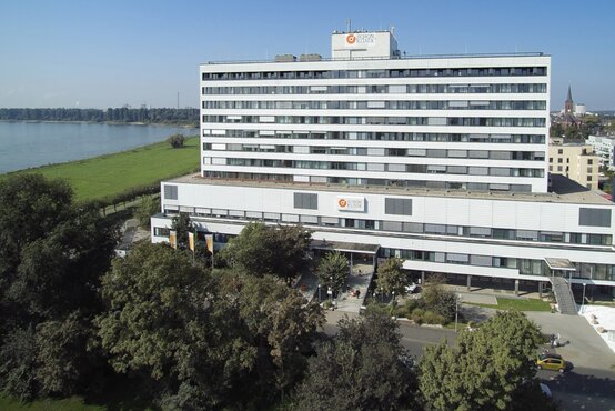 Luftaufnahme der Schön Klinik Düsseldorf, modernes Krankenhaus mit heller Fassade direkt am Rhein