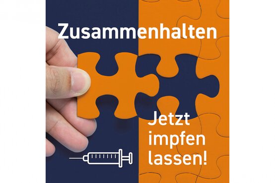 Hand hält orangefarbenes Puzzleteil vor zweifarbigem Hintergrund, Text „Zusammenhalten. Jetzt impfen lassen!“, darunter stilisierte Spritze