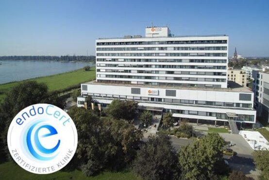 Luftaufnahme der Schön Klinik Düsseldorf am Rheinufer, modernes Klinikgebäude mit EndoCert-Qualitätssiegel im Vordergrund