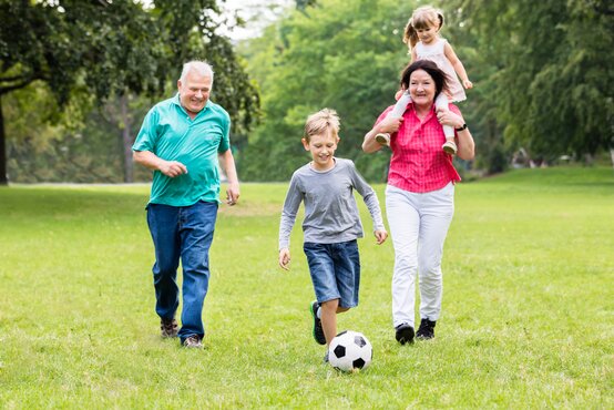 Fußballspiel mit Großeltern und Kindern im Garten