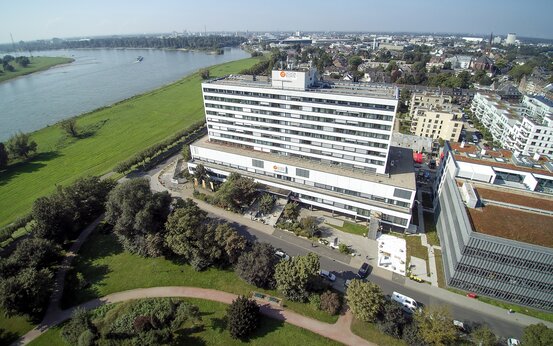 Luftaufnahme des modernen Klinikgebäudes der Schön Klinik Düsseldorf am Rhein