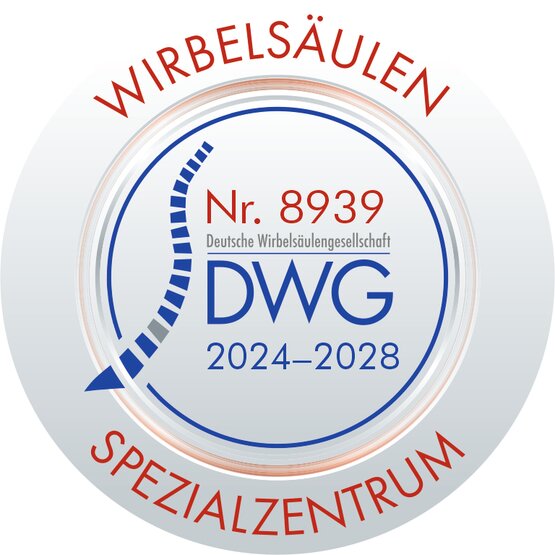 Rundes Siegel „Wirbelsäulen-Spezialzentrum DWG 2024–2028“ mit stilisierter blauer Wirbelsäule und roter Schrift, Zertifizierung der Deutschen Wirbelsäulengesellschaft