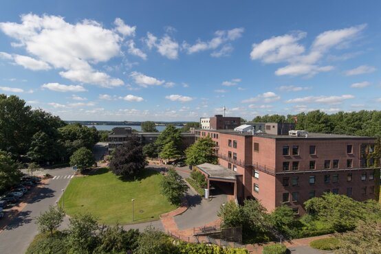 Luftaufnahme einer modernen Klinik mit rotem Ziegelbau, großem Eingangsbereich und gepflegter Grünanlage