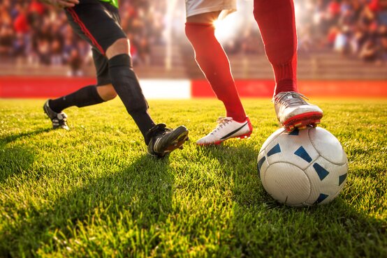 Zwei Fußballspieler im Zweikampf, Nahaufnahme der Beine und des Balls