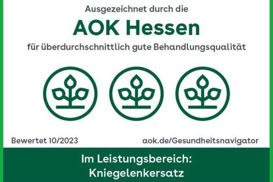 Grünes AOK-Qualitätssiegel 2023, rund mit AOK-Logo und Aufschrift „Kniegelenkersatz“