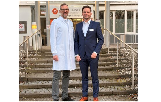 Zwei Männer vor dem Klinikeingang der Schön Klinik München Harlaching