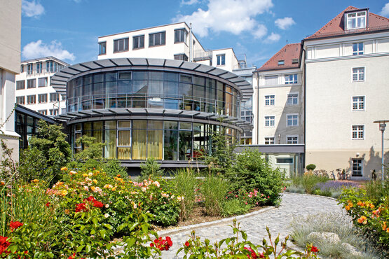 Modernes, rundes Gebäude der Schön Klinik München Schwabing mit Glasfassade und Lamellen