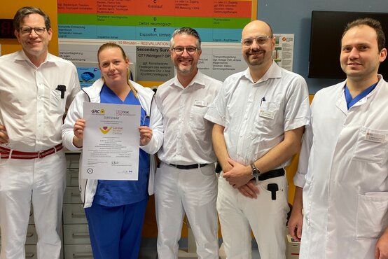 Fünf medizinische Fachkräfte in weißer Kleidung, Frau in der Mitte hält Zertifikat „Cardiac Center“, alle lächeln in die Kamera