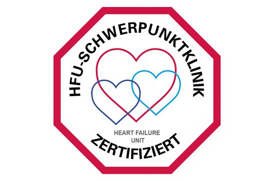 Oktagon mit rotem Rand, drei stilisierte Herzen, Text „HFU-Schwerpunktklinik Zertifiziert“ und „Heart Failure Unit“