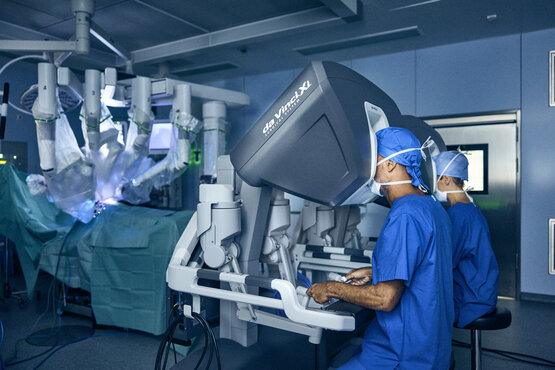 Roboterassistiertes da Vinci®-Operationssystem mit zwei Konsolen und mehreren Armen im modernen, hellen OP-Saal