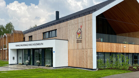 Modernes Ronald McDonald Haus Vogtareuth mit barrierefreiem Eingangsbereich, großem Schriftzug und Logo