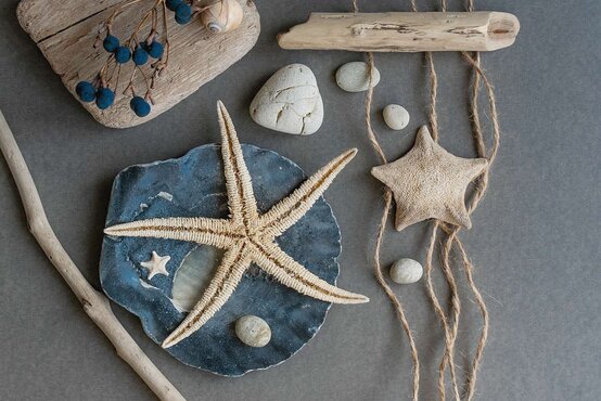 Maritime Deko aus Treibholz, Muscheln und Seilen auf Tisch, kreative Bastelarbeiten auf einem Tisch