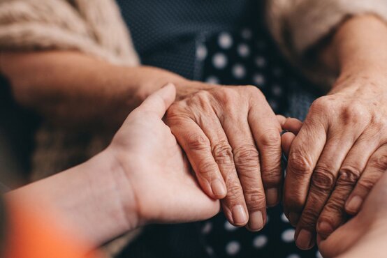 mann-oder-frau-haelt-die-haende-einer-aelteren-frau