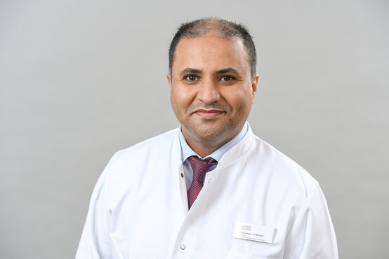 Abdulrahman Al-Mekhlafi. Porträt eines Arztes im weißen Kittel mit Namensschild