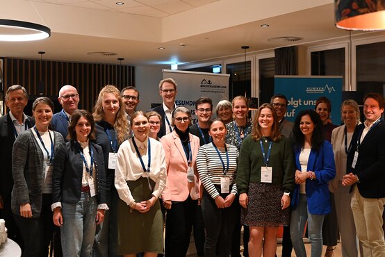 Gruppenfoto von 18 Personen mit Namensschildern beim Welcome-Abend der Gesundheitsregionplus Berchtesgadener Land