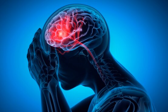 Grafik: Mensch hält sich mit beiden Händen den Kopf, Gehirn rot hervorgehoben