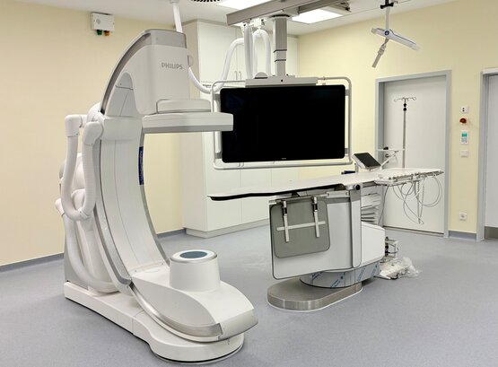 Großes bildgebendes Philips-Angiografiegerät mit C-Bogen, Monitor und höhenverstellbarem Patientenlagerungstisch