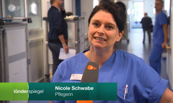 Screenshot eines ZDF-Interviews: Pflegekraft im blauen Kasack mit Namensschild, Bauchbinde „Nicole Schwab Pflegerin“, ZDF-Logo