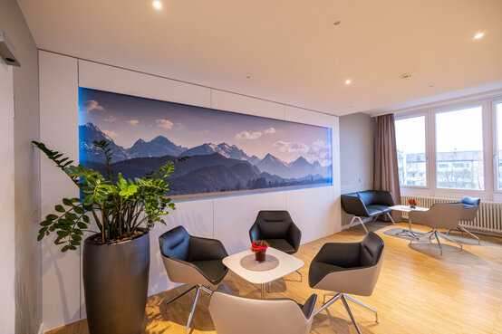 Privatlounge der Schön Klinik München Harlaching mit Designersesseln und Bergpanorama Bild